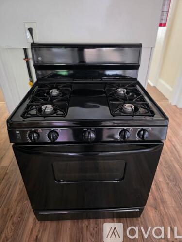 A black stove top oven with four burners and a front oven door.