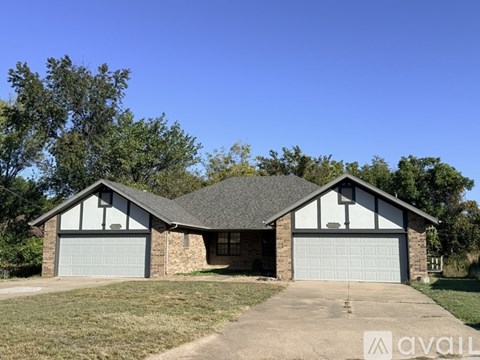 A two-car garage with a house in the background.
