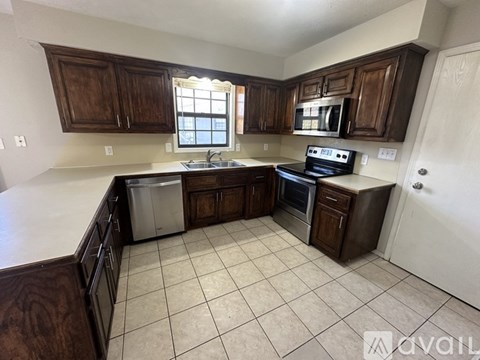 A kitchen with dark wood cabinets and white appliances.