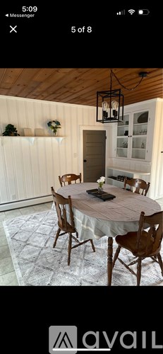 A dining room with a round table and chairs.