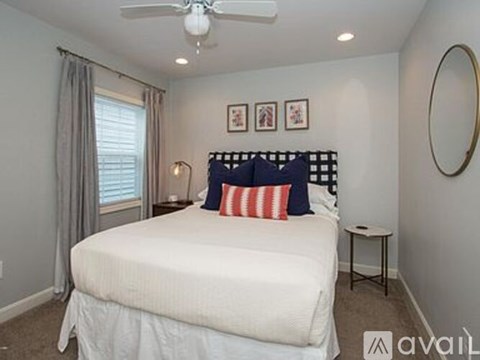 A bedroom with a white bed and a ceiling fan.