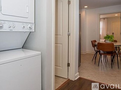 A white dishwasher is in a kitchen next to a white door.