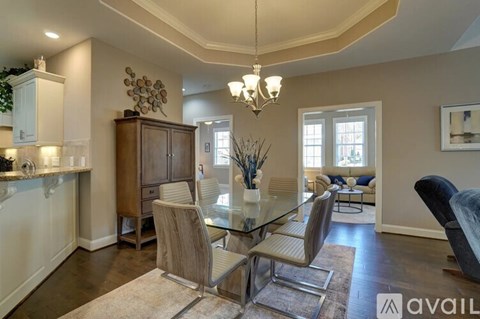 A modern dining room with a glass table and chairs.