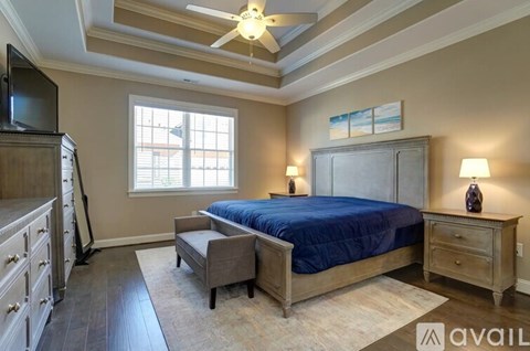 A bedroom with a bed, dresser, and ceiling fan.