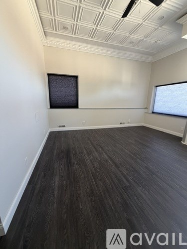A room with a wooden floor and a white ceiling with a window.