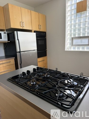 A kitchen with a stove top oven and a refrigerator.