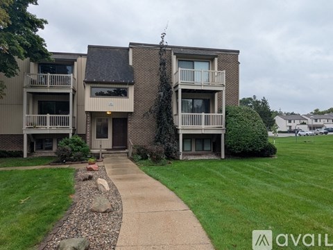 Apartment complex with a walkway leading to the front door.