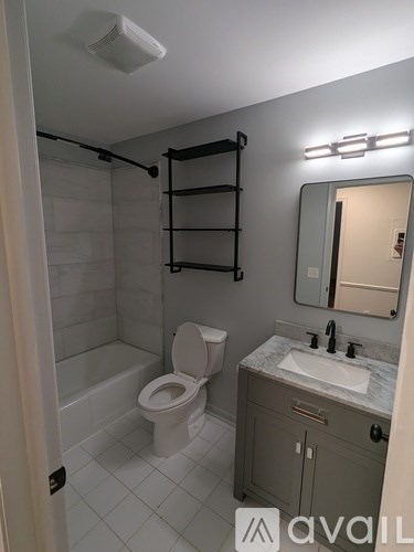 A bathroom with a toilet, sink, and a mirror.