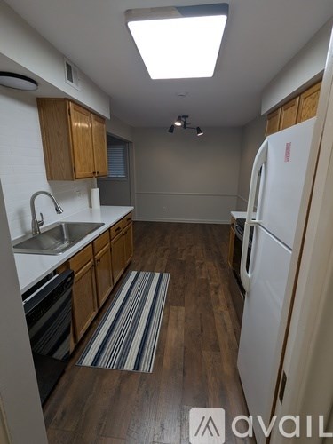 A kitchen with wooden cabinets and a white fridge.