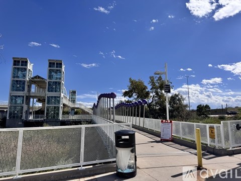 A fenced area with a trash bin and a sign in front of a building.