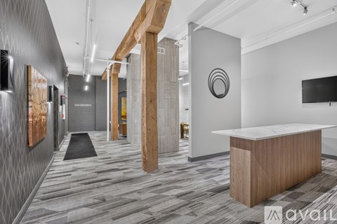 A modern office space with a reception desk and a television mounted on the wall.
