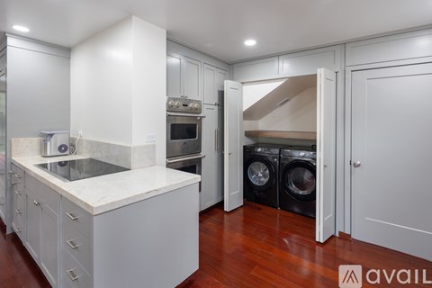 A modern kitchen with white cabinets and a marble countertop.