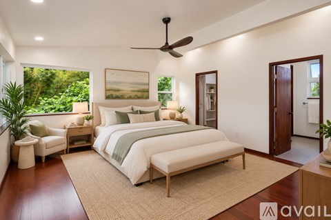 A bedroom with a large bed and a ceiling fan.