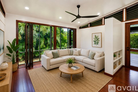A living room with a white couch and a ceiling fan.