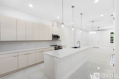 A modern kitchen with white cabinets and a large island.