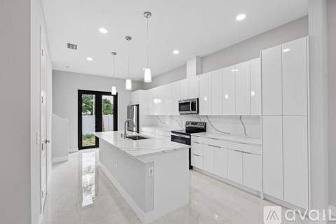 A modern kitchen with white cabinets and a large island.