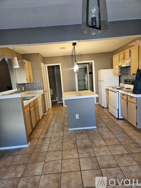 A kitchen with a white fridge and a white dishwasher.