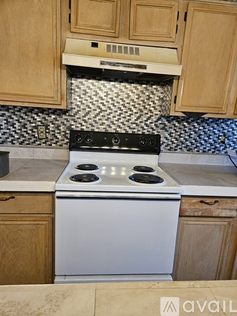A white oven with a black stove top sits in a kitchen.