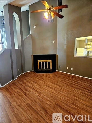 A room with a fireplace and a ceiling fan.