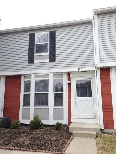 A red and grey house with a white door and windows.