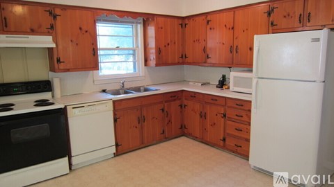 A kitchen with wooden cabinets and white appliances.