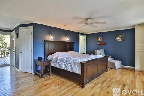 A bedroom with a bed, nightstand, and a ceiling fan.