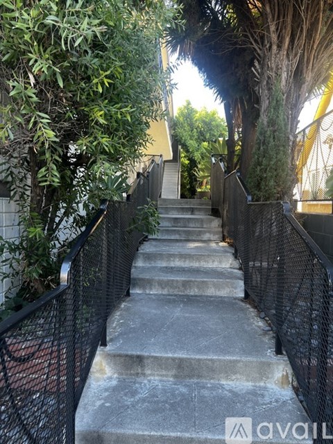 A set of stone steps with a metal railing on one side.