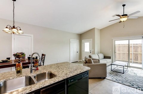 A kitchen with granite countertops and a dining table set for a meal.