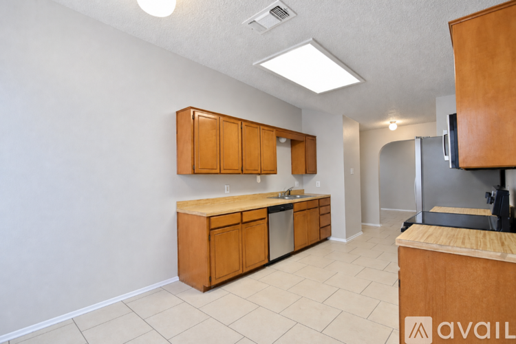 A kitchen with wooden cabinets and a refrigerator.