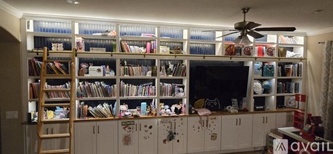 A living room with a television and a bookshelf filled with books.