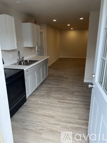 A kitchen with white cabinets and a black oven.