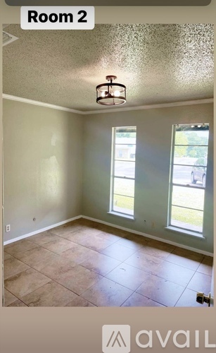A room with a window and a ceiling light.