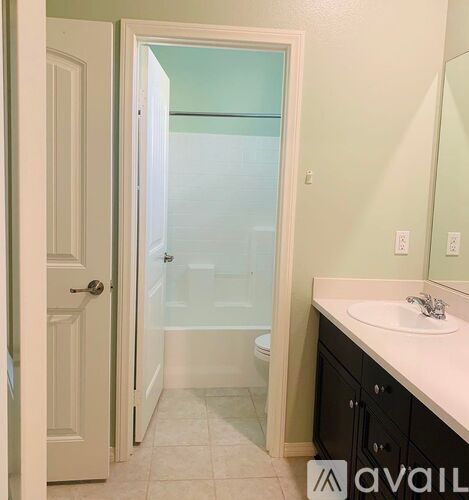 A bathroom with a white sink and a glass shower door.