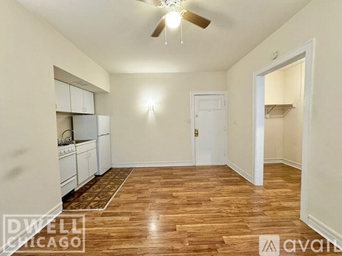 A room with a ceiling fan and wooden flooring.