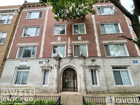 A brick building with a large front door and windows on the second floor.