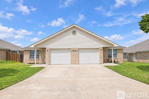 A house with a garage and driveway in front of it.