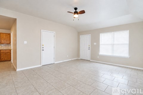 A spacious room with a ceiling fan and tiled flooring.
