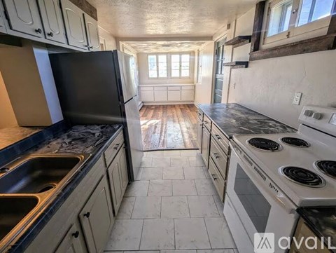 A kitchen with black appliances and white cabinets.