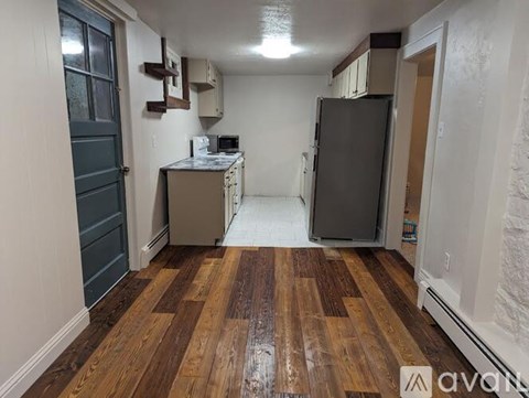 A kitchen with a refrigerator and a counter.