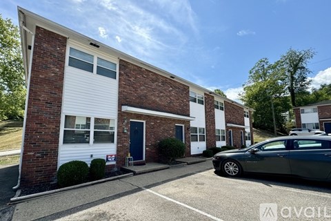 A brick building with a car parked in front.