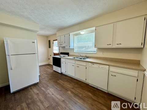 A kitchen with white appliances and cabinets.