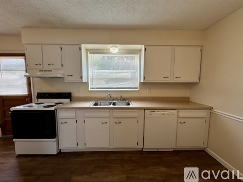 A kitchen with white cabinets and a black stove top oven.