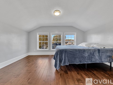 A bedroom with a bed and a window with a view of the outside.