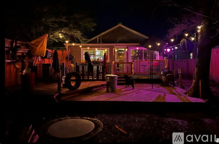 A nighttime scene of a bar with a dog on the patio.