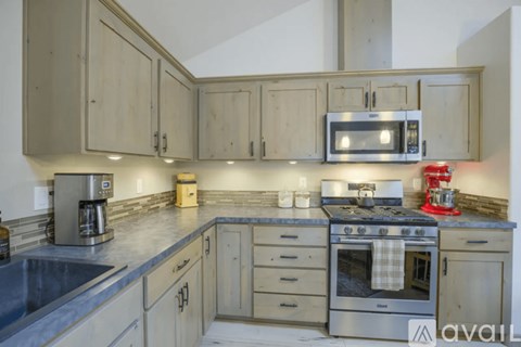 A kitchen with wooden cabinets and a stainless steel oven.