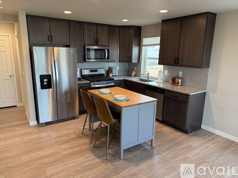 A kitchen with a table and chairs in the middle of the room.