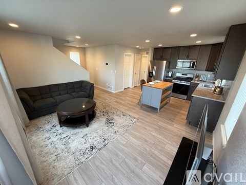 A modern living room with a black leather couch and a wooden coffee table.