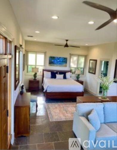 A spacious bedroom with a large bed and a ceiling fan.