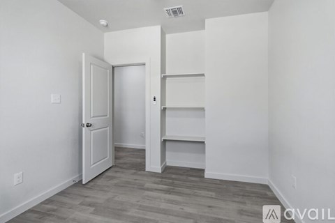 A room with a white door and shelves.