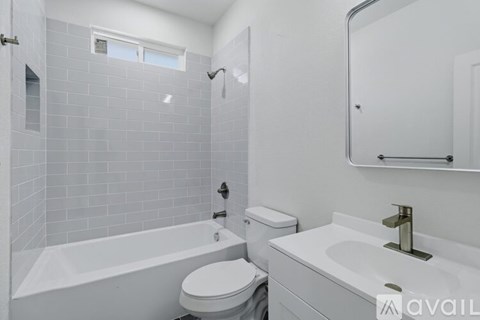 A white bathroom with a tub, toilet, and sink.